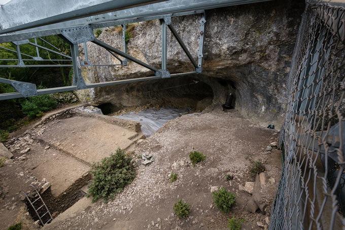 A view from the eyes of a cave behind what looks like the foundations of a building